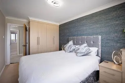 a bedroom with a white bed and a brick wall at The Beachcomber - seafront, free parking, free wifi in Cleveleys
