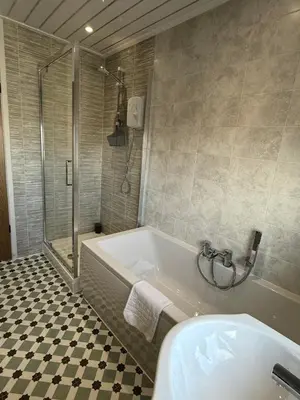 a bathroom with a tub and a shower and a sink at The Beachcomber - seafront, free parking, free wifi in Cleveleys