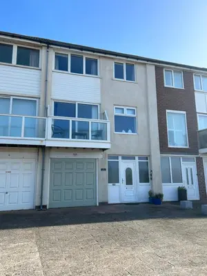 an apartment building with two garage doors and a balcony at The Beachcomber - seafront, free parking, free wifi in Cleveleys