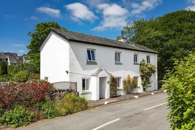 a white house on the side of a road at heft view at rose cottage - opp heft restaurant in Grange Over Sands
