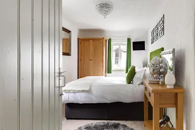 a bedroom with a bed and a table and a window at heft view at rose cottage - opp heft restaurant in Grange Over Sands
