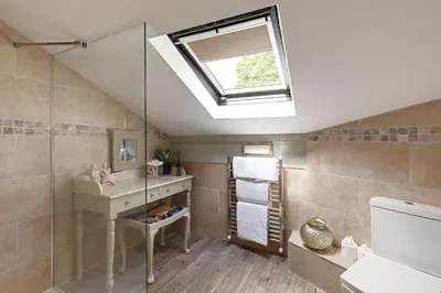 a bathroom with a sink and a shower with a skylight at heft view at rose cottage - opp heft restaurant in Grange Over Sands