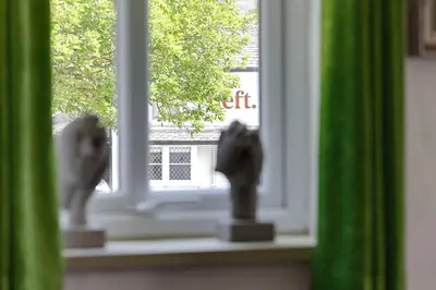 a window with two statues of cats on a window sill at heft view at rose cottage - opp heft restaurant in Grange Over Sands