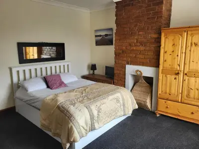 a bedroom with a bed and a brick wall at Cosy cottage in Chorley