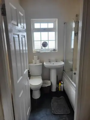 a bathroom with a toilet and a sink and a window at Cosy cottage in Chorley