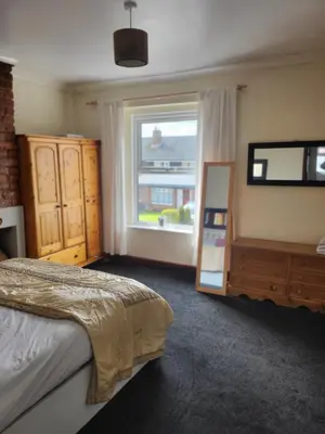 a bedroom with a bed and a large window at Cosy cottage in Chorley