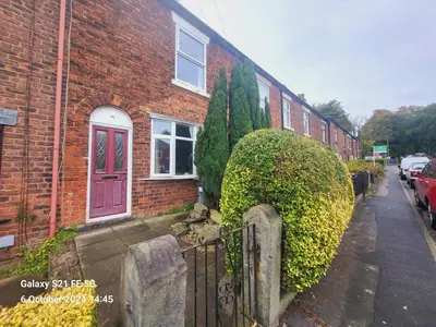 a brick house with a gate and a bush at Cottage - Sleeps 4 - Garden - Parking in Chorley
