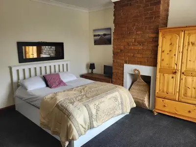a bedroom with a bed and a brick wall at Cottage - Sleeps 4 - Garden - Parking in Chorley