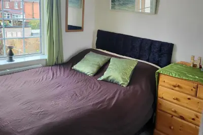 a bed with two pillows sitting next to a window at Cottage - Sleeps 4 - Garden - Parking in Chorley