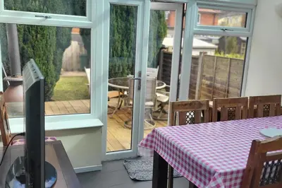 a room with a table and a patio with sliding doors at Cottage - Sleeps 4 - Garden - Parking in Chorley