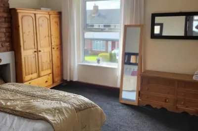 a bedroom with a bed and a dresser and a window at Cottage - Sleeps 4 - Garden - Parking in Chorley
