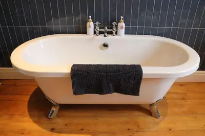 a white bath tub with a black towel on it at 3 double bed whole house by castle in Lancaster