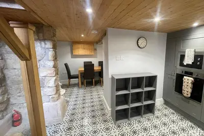 a kitchen and dining room with a table and a clock at 3 double bed whole house by castle in Lancaster