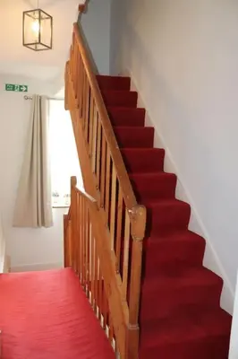 a staircase with red carpet and a red rug at 3 double bed whole house by castle in Lancaster