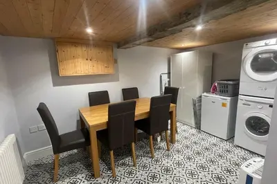 a dining room table with black chairs and a washer and dryer at 3 double bed whole house by castle in Lancaster