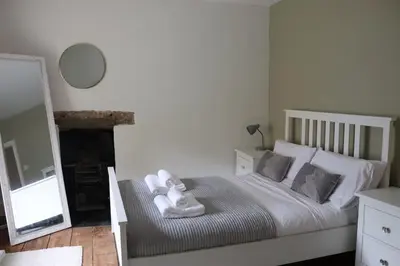 a bedroom with a bed with towels on it at 3 double bed whole house by castle in Lancaster