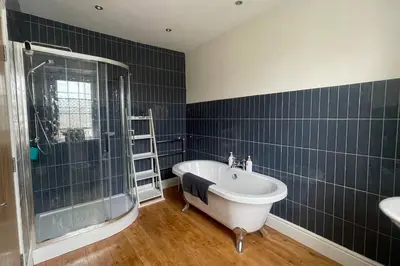 a bathroom with a tub and a shower and a sink at 3 double bed whole house by castle in Lancaster