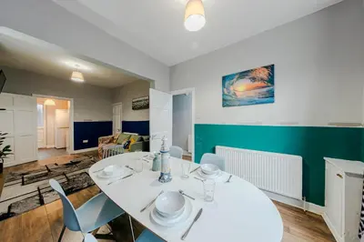 a dining room with a white table and chairs at Spacious 3-Bedroom Liverpool Home Sleeps 6 Great Transport Links in Liverpool