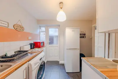 a kitchen with a white refrigerator and a sink at Spacious 3-Bedroom Liverpool Home Sleeps 6 Great Transport Links in Liverpool