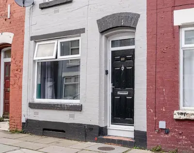 a black door on the side of a brick building at Spacious 3-Bedroom Liverpool Home Sleeps 6 Great Transport Links in Liverpool