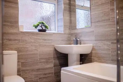 a bathroom with a sink and a toilet and a mirror at Spacious 3-Bedroom Liverpool Home Sleeps 6 Great Transport Links in Liverpool