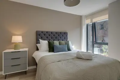 a white bedroom with a large bed and a window at Richmond Row Apartments - Free On-Site Parking, WiFi & EV in Liverpool