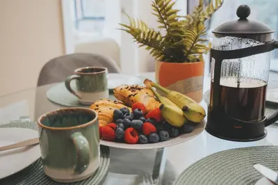 a plate of fruit on a table with two cups at Richmond Row Apartments - Free On-Site Parking, WiFi & EV in Liverpool