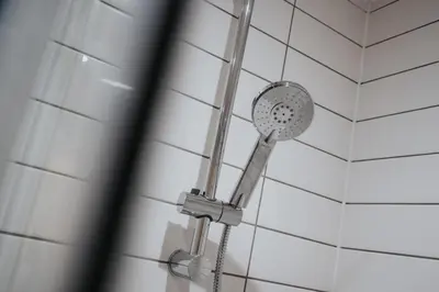 a shower in a bathroom with white tiles at Richmond Row Apartments - Free On-Site Parking, WiFi & EV in Liverpool