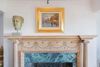 a fireplace with a painting and a bust above it at Bayview House Silverdale in Silverdale