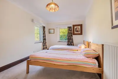 two twin beds in a room with two windows at Bayview House Silverdale in Silverdale