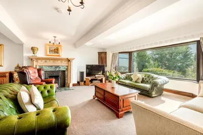 a living room with green furniture and a fireplace at Bayview House Silverdale in Silverdale