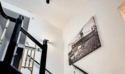 a picture hanging on a wall next to a staircase at Mathew Street 1 bed apt sleeps 6 in Liverpool