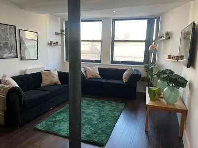 a living room with a blue couch and a table at Mathew Street 1 bed apt sleeps 6 in Liverpool