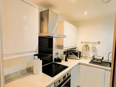 a kitchen with white cabinets and a stove top oven at Mathew Street 1 bed apt sleeps 6 in Liverpool