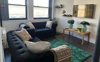 a living room with a couch and a table at Mathew Street 1 bed apt sleeps 6 in Liverpool