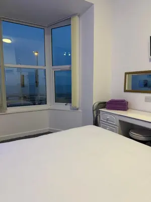a bedroom with a bed and a desk and a window at The Charlton - Aparthotel in Blackpool