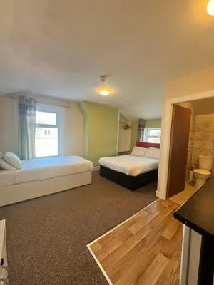 a bedroom with two beds and a window at The Charlton - Aparthotel in Blackpool