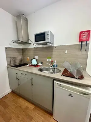 a kitchen with a sink and a microwave at The Charlton - Aparthotel in Blackpool