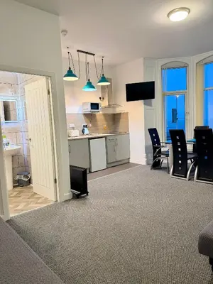a kitchen and dining room with chairs and a table at The Charlton - Aparthotel in Blackpool