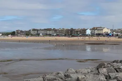 a beach with a group of people on the sand at Modern and comfortable stay in Morecambe in Morecambe