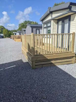 a home with a wooden deck on a lot at Lytham Luxe 6 Birth Caravan in Weeton