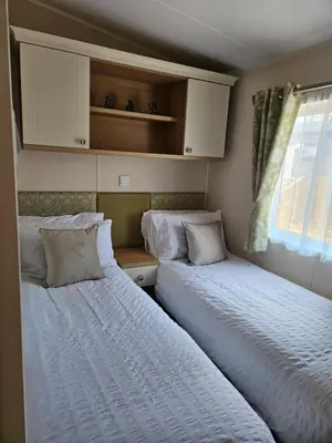 two beds sitting next to each other in a bedroom at Lytham Luxe 6 Birth Caravan in Weeton