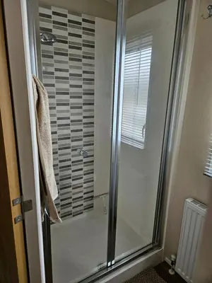 a shower with a glass door in a bathroom at Lytham Luxe 6 Birth Caravan in Weeton