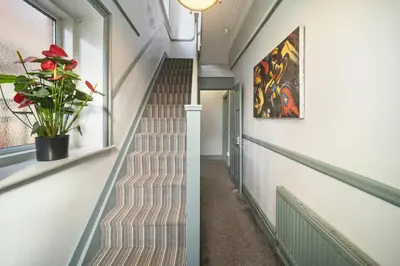 a staircase in a house with a plant at Spacious, Central Townhouse with Hot Tub & Free Parking in Lytham St Annes