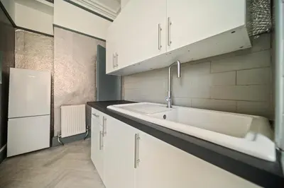 a kitchen with a sink and a refrigerator at Spacious, Central Townhouse with Hot Tub & Free Parking in Lytham St Annes