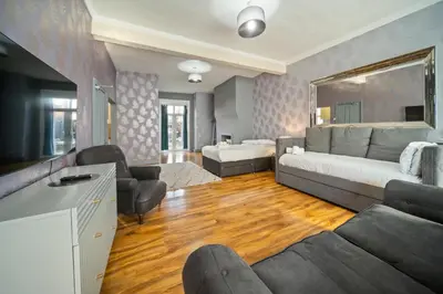 a living room with a couch and a tv and a living room at Spacious, Central Townhouse with Hot Tub & Free Parking in Lytham St Annes
