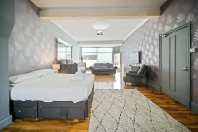 a bedroom with a bed and a living room at Spacious, Central Townhouse with Hot Tub & Free Parking in Lytham St Annes