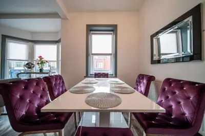 a dining room with a table and purple chairs at Spacious, Central Townhouse with Hot Tub & Free Parking in Lytham St Annes