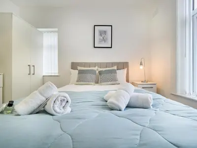 a bedroom with a large bed with towels on it at Woodcroft House - Air Host & Stay - 4 Bedrooms in Liverpool