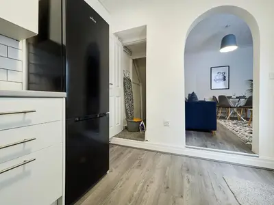 a kitchen with a black refrigerator and a dining room at Woodcroft House - Air Host & Stay - 4 Bedrooms in Liverpool